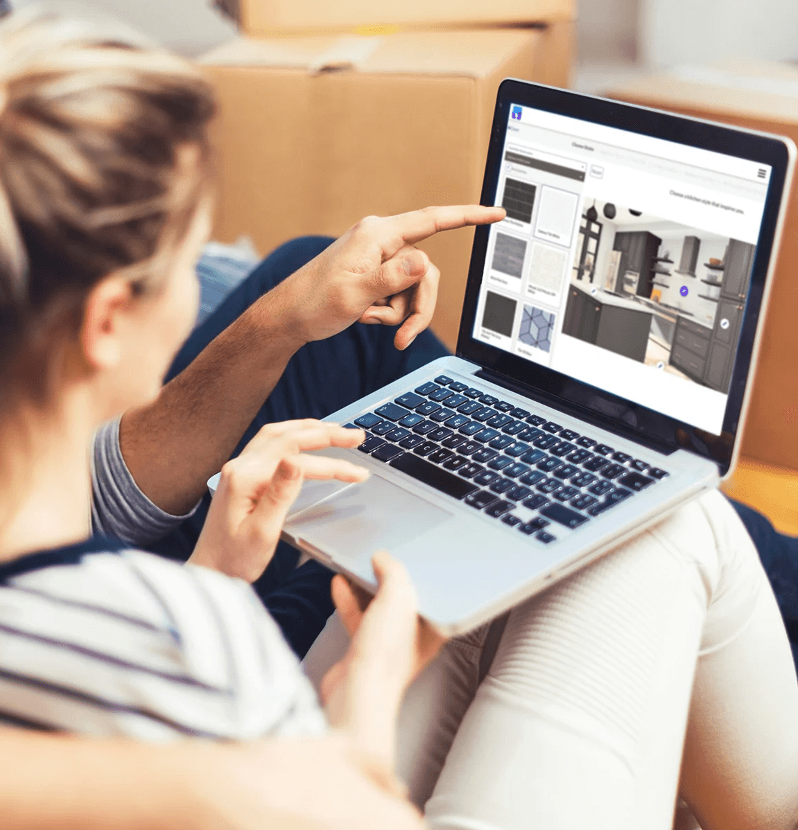 Customer reviewing the kitchen design board on a laptop with the designer